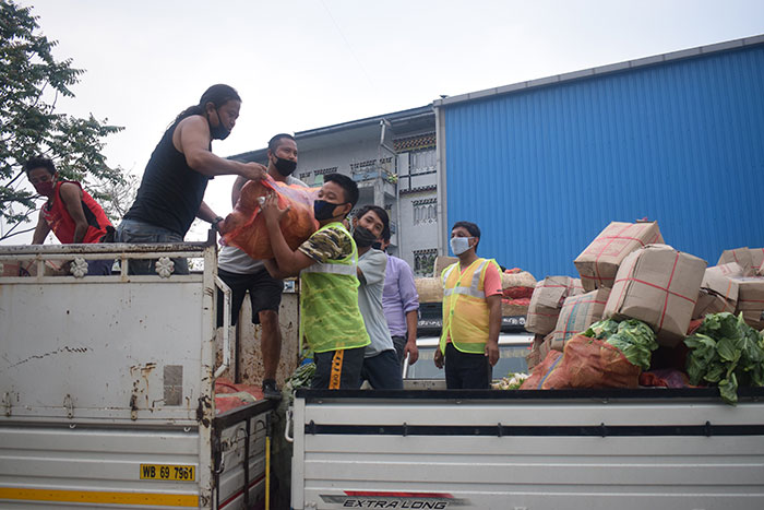   At the mini dry port: Happiness centre recovery team shifting vegetables to a Bhutanese carrier